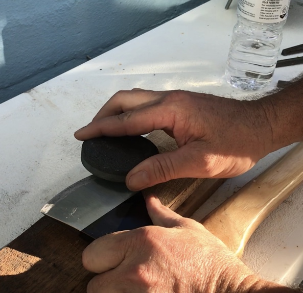 Fine tuning an axe edge with a wet stone