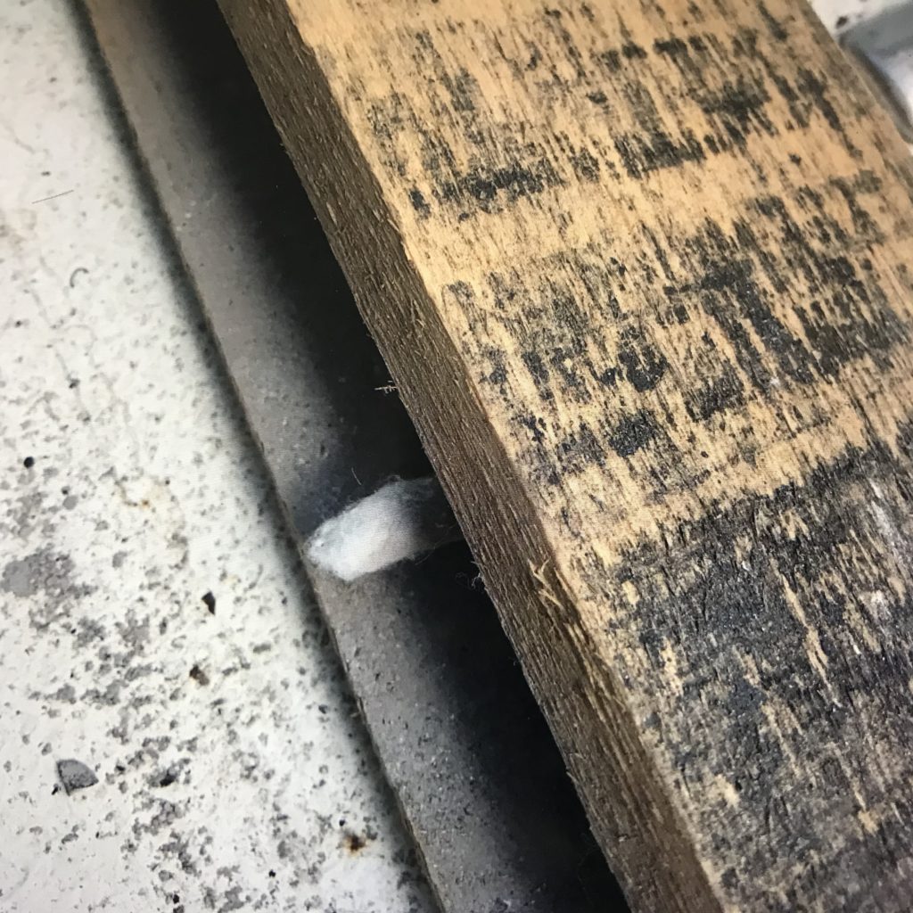 A tightly rolled cotton ball with wood ash rolled between two flat boards Being rolled fast between the boards